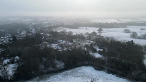 Casa-Grande-De-Campo-Inglés-Cubierta-De-Nieve-En-Primer-Plano-Pan-Aéreo-4k