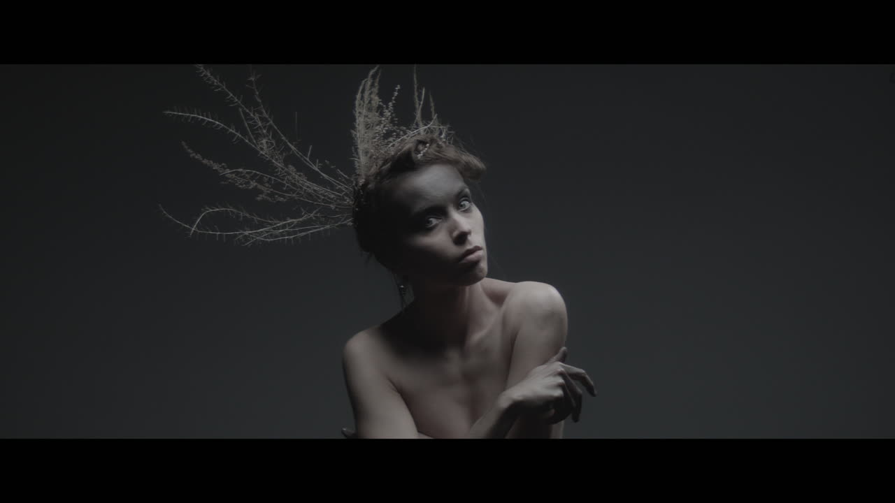 A woman dressed as mother nature moves slowly in a dance-like motion