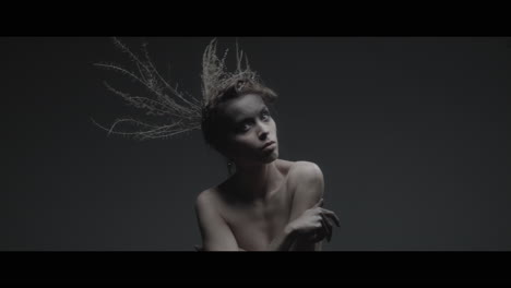 a woman dressed as mother nature moves slowly in a dance-like motion