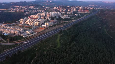 aerial view of a highway passing through a residential area and forest