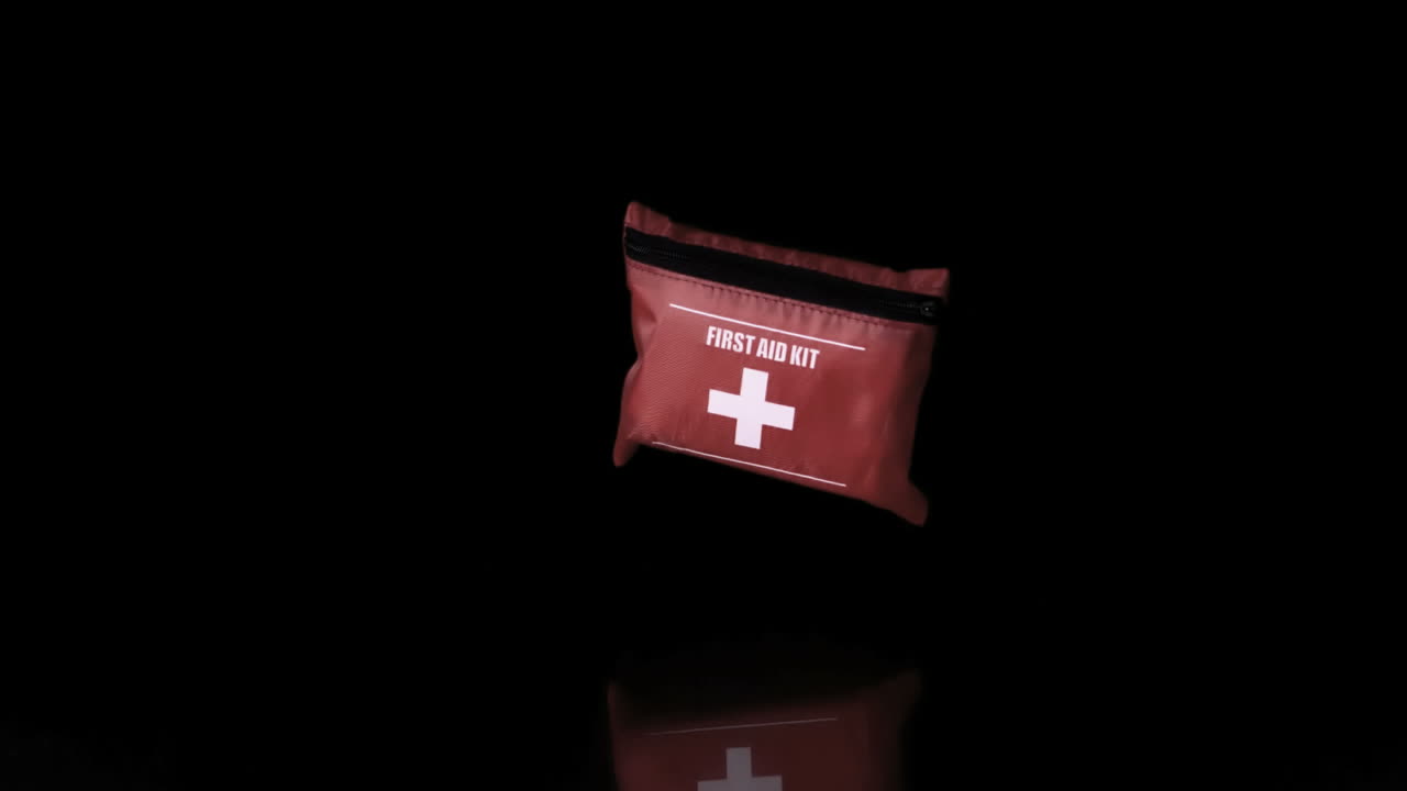 First aid kit falling on black background