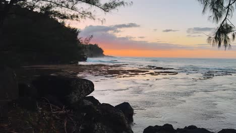 experience a tropical dreamscape with stunning footage of a sunset over hawaii’s coastline, as ocean waves gently crash against the shore, glowing in the warm, golden light.