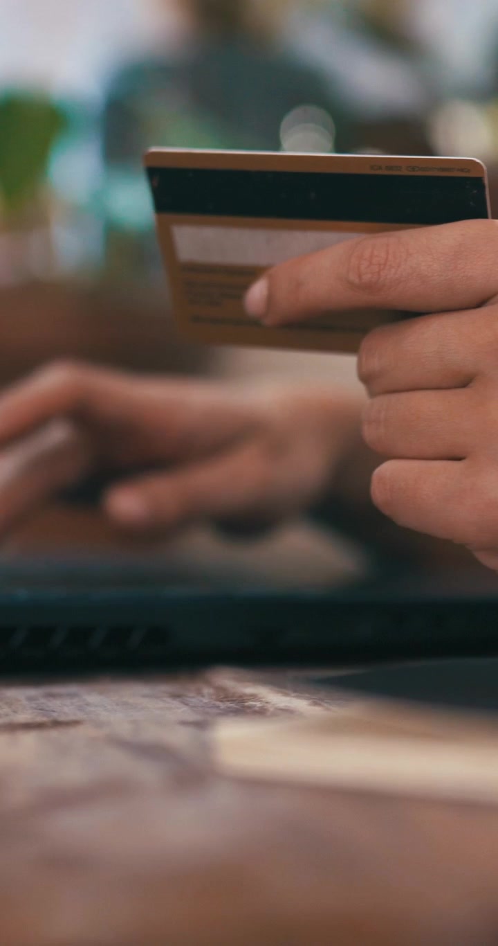 Persona che effettua un acquisto online con carta di credito sul laptop