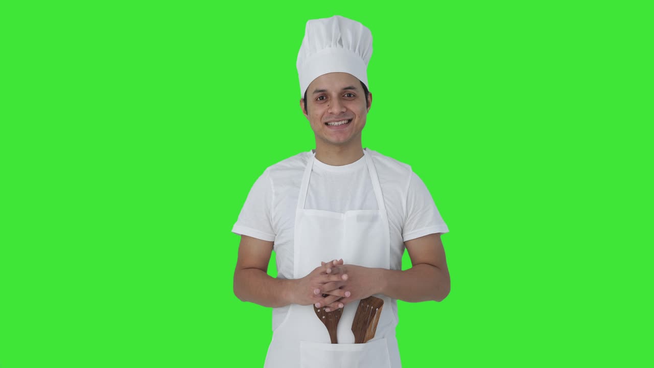 Chef professionista indiano felice che sorride alla telecamera Schermo verde