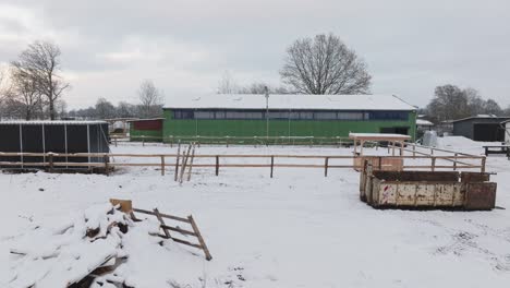 Aerial-view-of-a-snowy-farm-with-horses-in-northern-germany