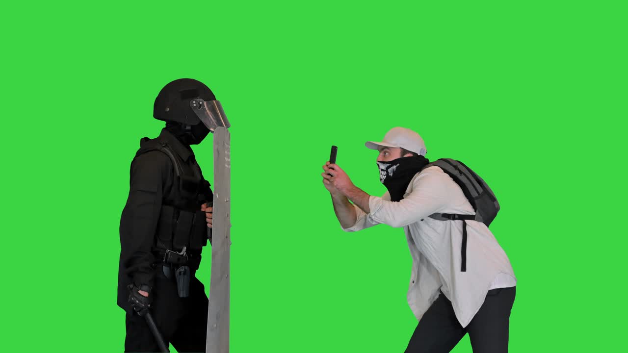 Manifestante agressivo filmando a polícia de choque no smartphone em uma Tela Verde, Chroma Key