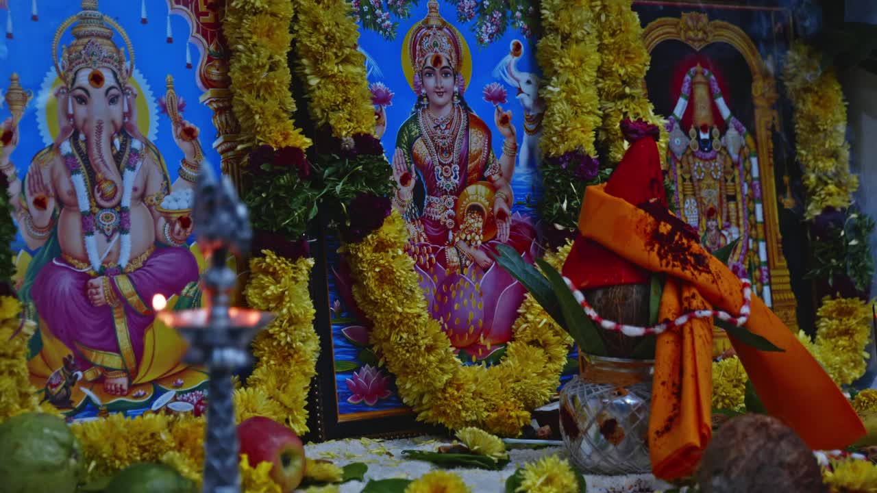 Indian gods ganapathi, laxmi devi, Venkateshwara photo frames with Flower garlands, ceremonial pot
or silver pot and coconut in india. stable shot, 4k.