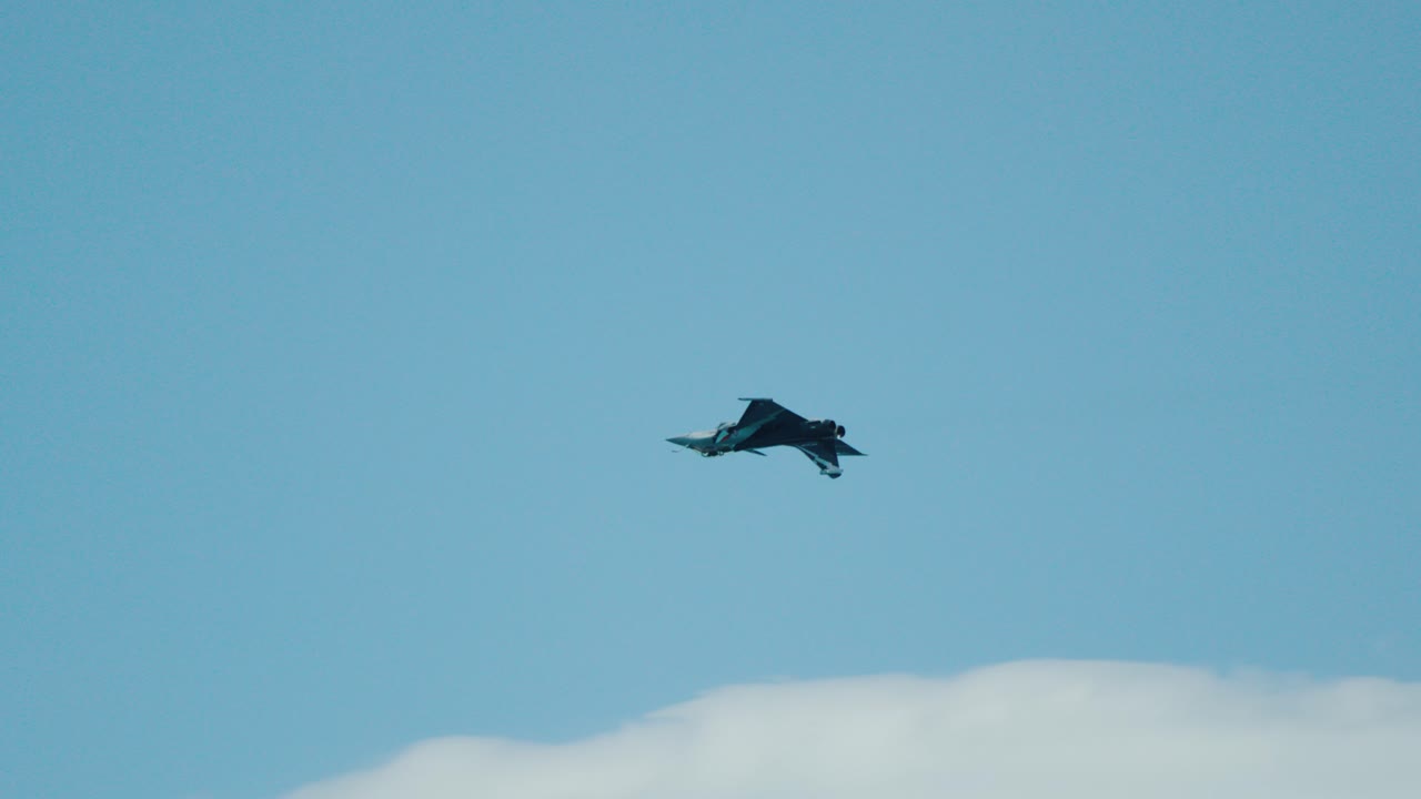 Powerful French Rafale jetplane streaks across blue sky at Patrouille de France
