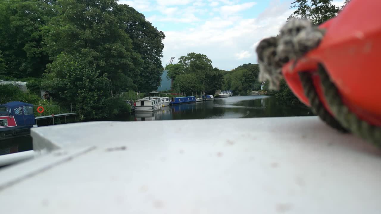 Close drone establishing of canal boat navigating under a bridge in Maidstone, Kent, England