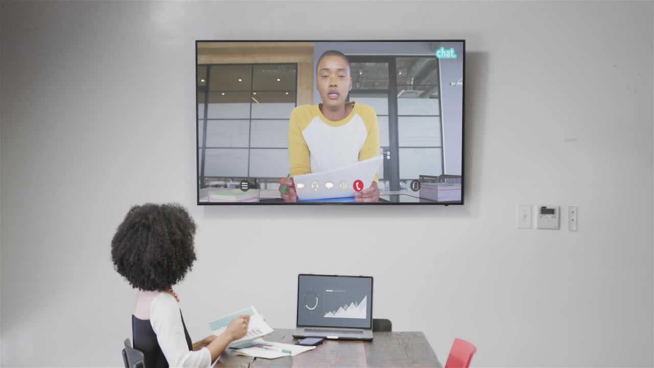 mujer de negocios afroamericana en videollamada con un colega afroamericano en la pantalla