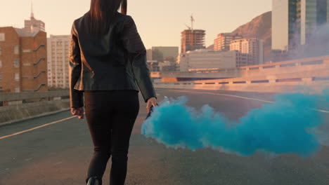 confident woman holding smoke grenade walking in city street at sunrise rebellious female activist protesting