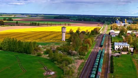 aerial view of joniškis with beautiful landscape of fields, railway, and water tower