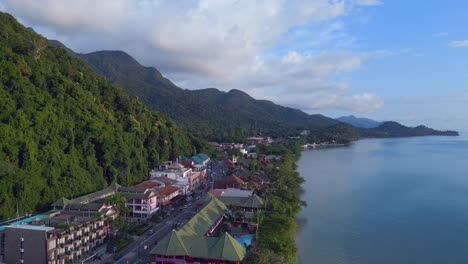 perfect aerial top view flight
beach village huts resort, tropical bungalows on mountainous island thailand 2022