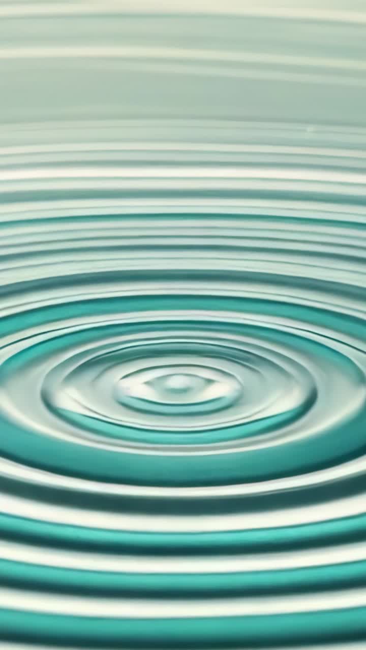 Vertical video: Droplet impacting water surface in pool, sending concentric ripple rings outward