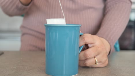 bolsas de té y taza amarilla en la mesa