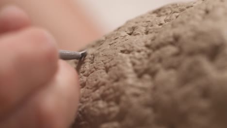 a close-up of an inspired potter shaping ceramics pot. clay product made with professional tools. artist working in workshop. creating modern art product