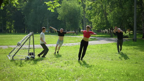 A family plays an outdoor soccer game, where the young son kicks the ball as they celebrate and the goalkeeper sits on the ground, covering his face in shame after missing the save