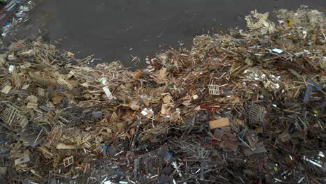 aerial shot of wood and timber pallets discarded at a waste landfill, trash recovery transfer station