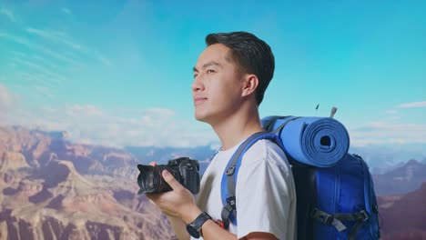 Close Up Side View Of Asian Male Hiker With Mountaineering Backpack Holding A Camera In His Hands Then Looking Around While Traveling At The Top Of Mountain