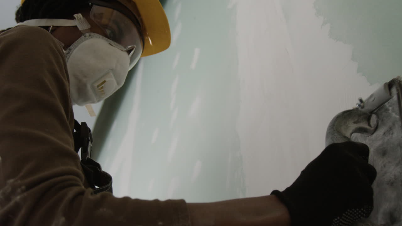A worker plastering a wall
