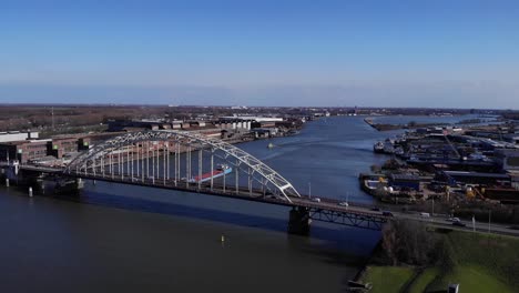 barge sailing in the river passing under noord arch bridge with hendrik-ido-ambacht, netherlands