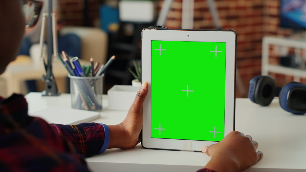 Office worker vertically holding wireless gadget with greenscreen display