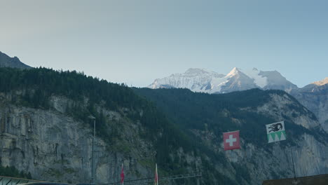 the scene showed beautiful mountains with greenery and snowy peaks observer's eyes focused on two flags gracefully suspended on one side