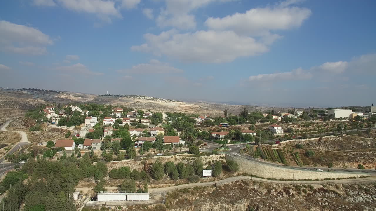 Vista aerea di un villaggio collinare e di impianti industriali