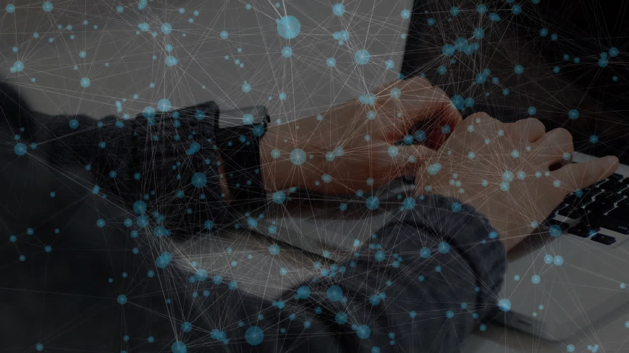 Developer typing at office desk, displaying blue network nodes and connecting lines in technology