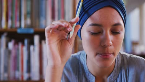 Asian-female-student-wearing-a-blue-hijab-sitting-and-thinking-with-eyes-closed