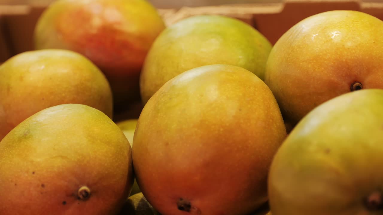 High-quality mangoes displayed in wooden crates at a market, perfect for tropical and exotic themes.