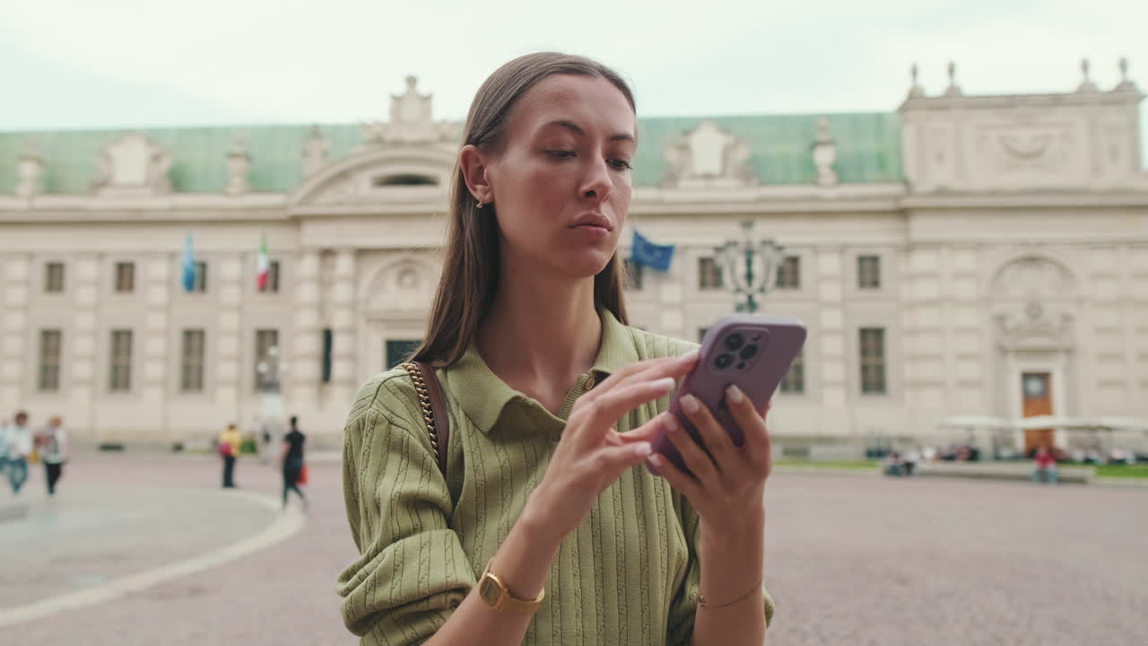 Young Woman Using Smartphone in European City Square