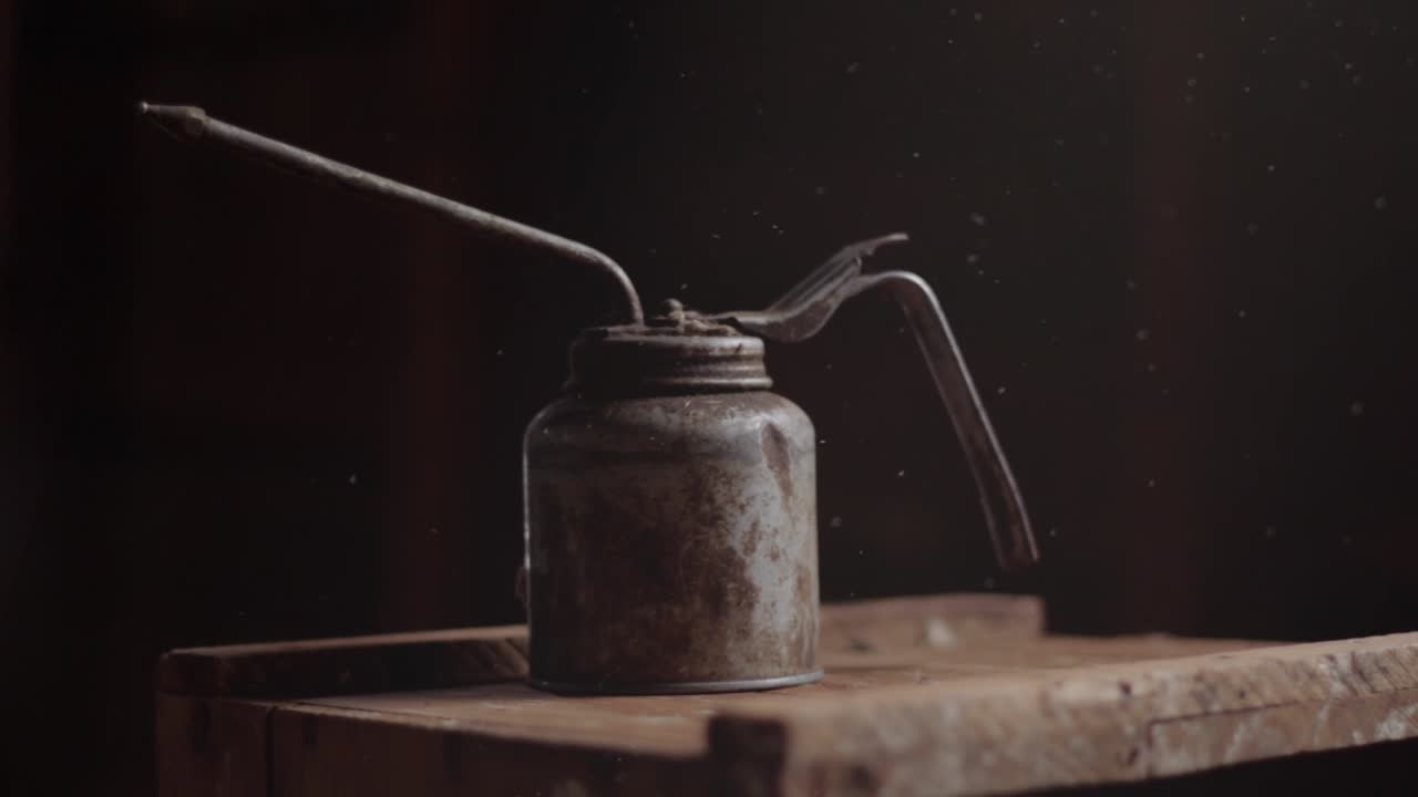 먼지가 있는 나무 상자에 있는 골동품 오일 캔