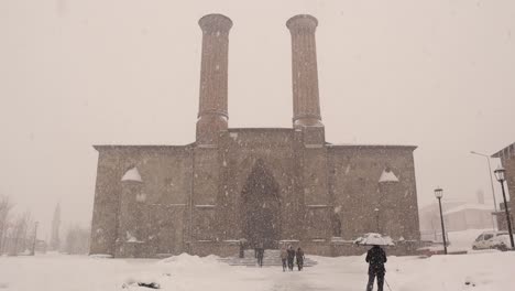 erzurum in turkey during a snow storm.
turkey travel. twin minaret school (turkish: çifte minareli medrese). twin minaret madrasa, madrasah. snow on islamic ancient building, winter season