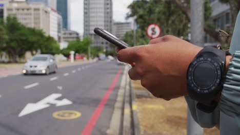 las manos de una mujer de negocios afroamericana usando un teléfono inteligente