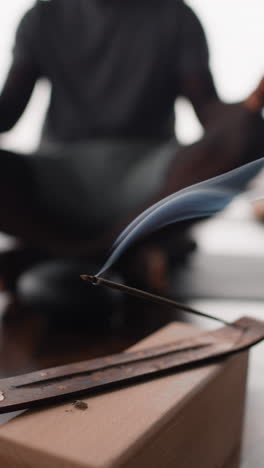man meditating with incense