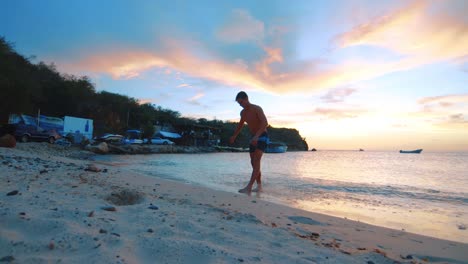 Slowmo,-Joven-Haciendo-Backflip-En-La-Playa,-Colorido-Atardecer-En-Curacao,-Caribe