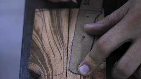 hand drawing the contour of a knife handle with pencil in a piece of paper