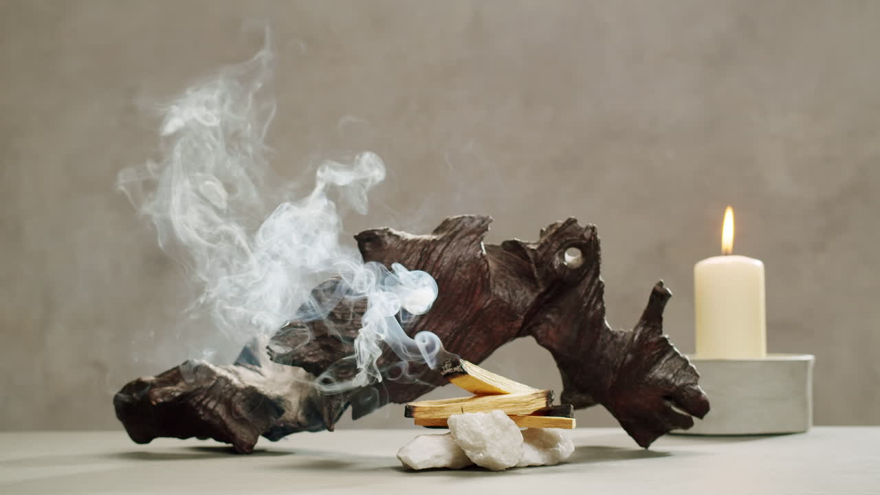 Person holding Palo Santo wood stick in hand, aromatic Palo Santo burning on black background, smoke spreading around, slow motion video clip, high quality 4k close up footage. High quality 4k footage