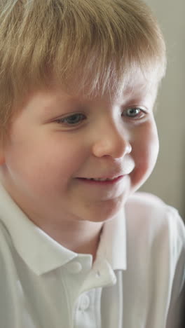 niño en edad preescolar abre la boca emocionado viendo dibujos animados en la computadora. niño pequeño emocional sonríe y lame el labio reaccionando a la acción en el primer plano de la pantalla