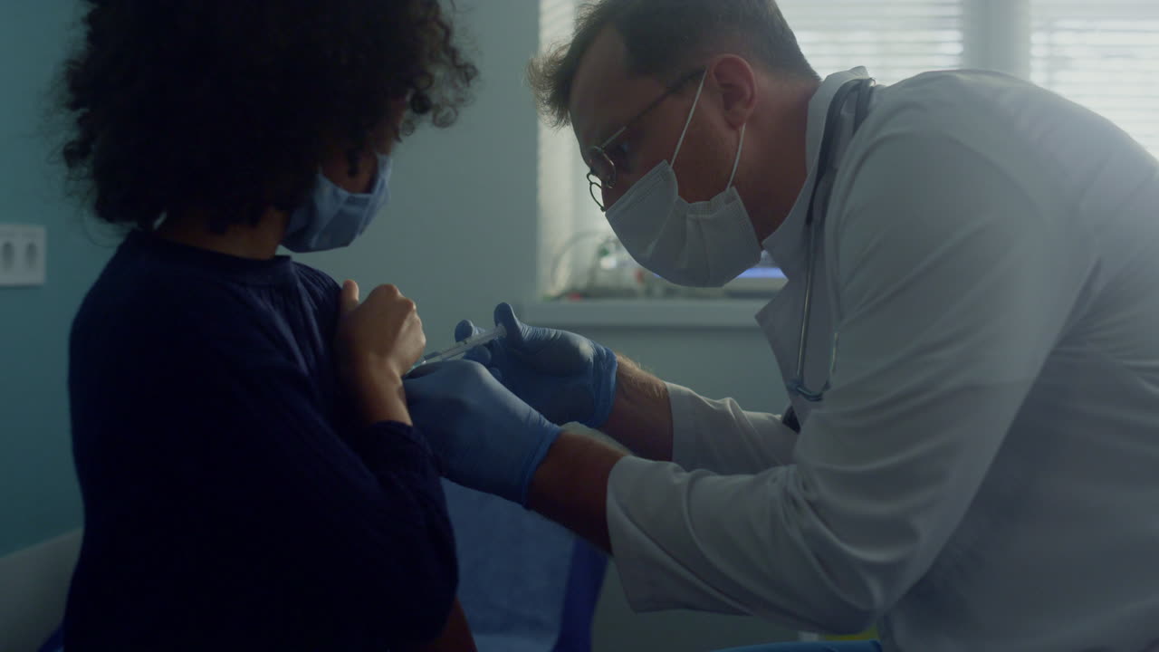 Girl taking dose covid vaccine in clinic close up. Doctor making injection.