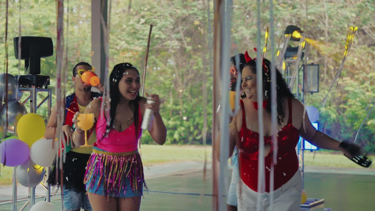 A vibrant outdoor party with people celebrating amidst confetti and colorful costumes