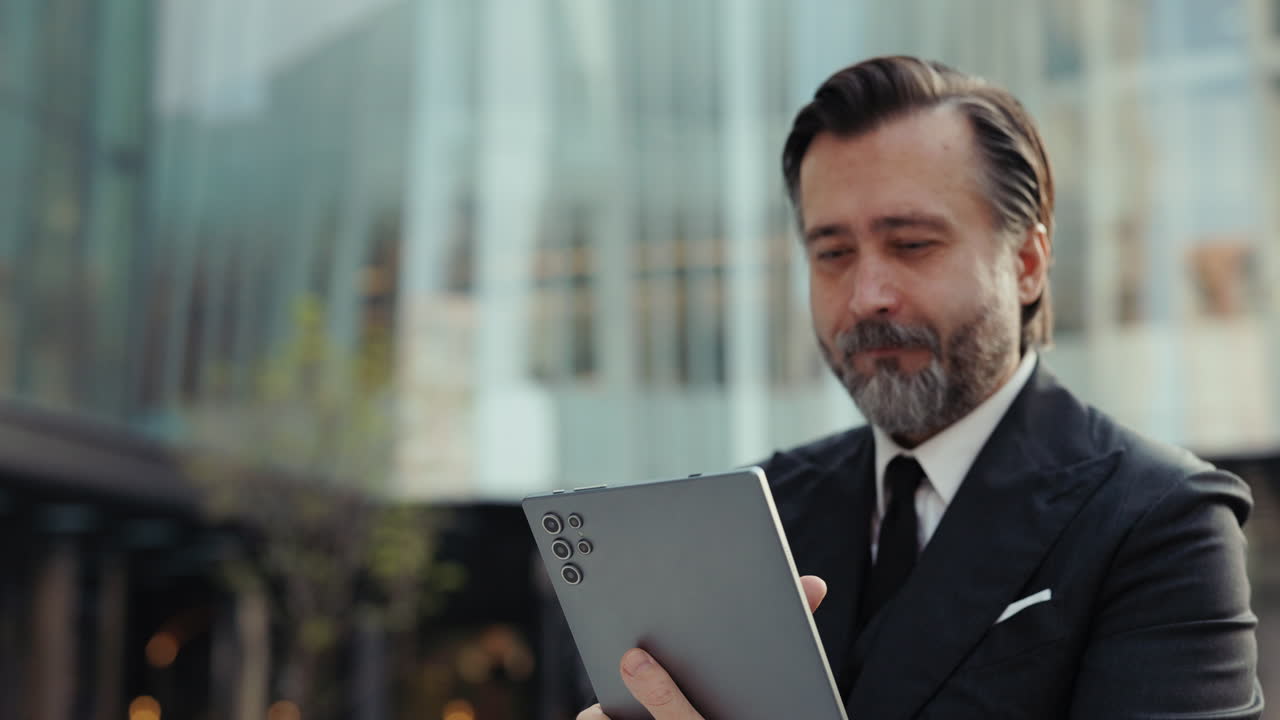 Empresário focado usando tablet digital ao ar livre.