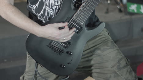 guitarist playing on a black seven string guitar