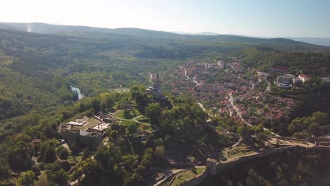 panning, elevating drone shot of a church on a hill with an archeological site in veliko tarnovo