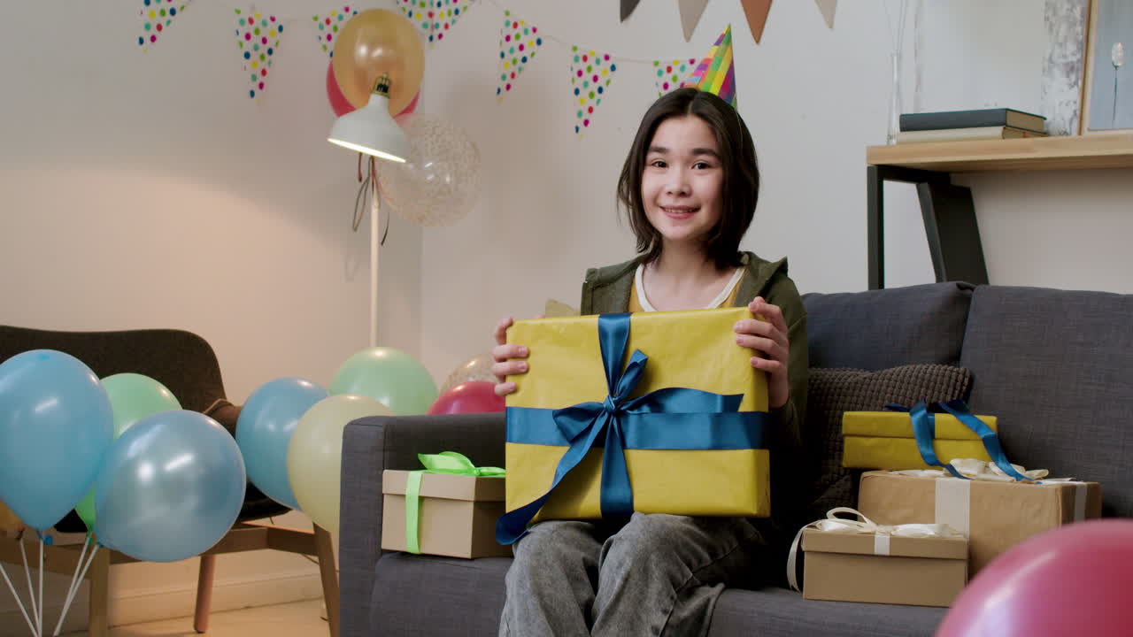 소파에서 포즈를 취하는 파티 모자를 입은 소녀