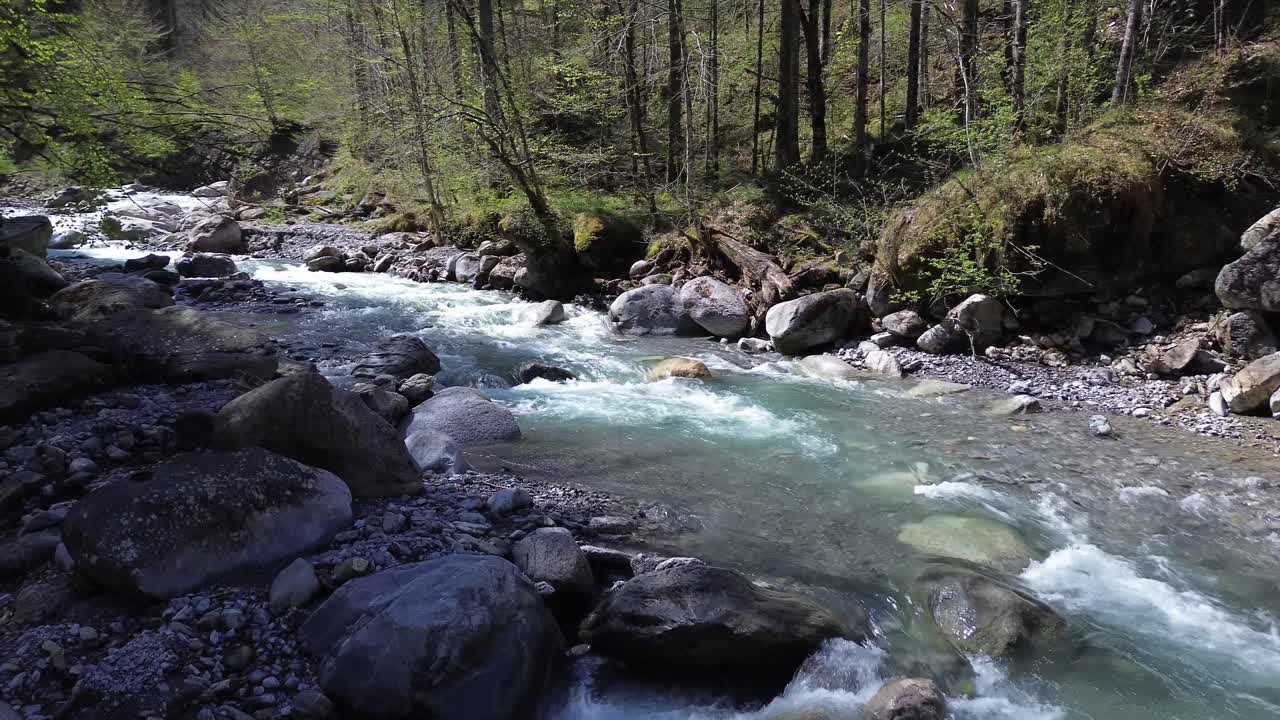 Idyllisk flod med krystalklart turkisblåt vand omgivet af skov.