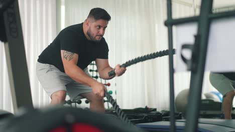 joven doble ejercicio de azotes con cuerdas de batalla en un gimnasio
