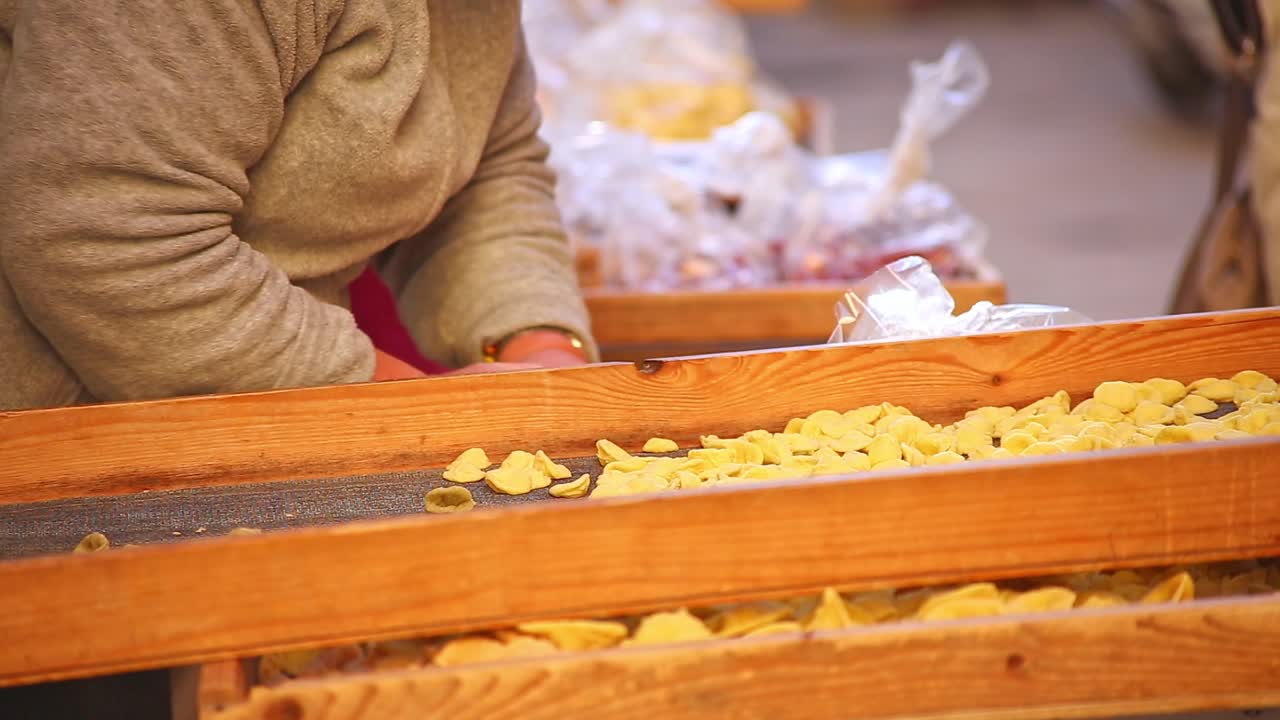cerca de las manos de las damas preparando y vendiendo comida en el mercado italiano