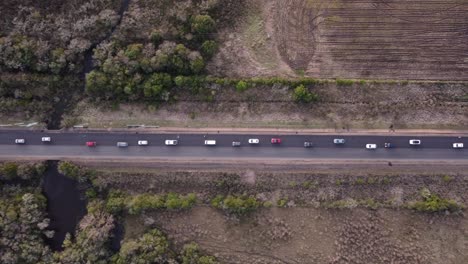 aerial view of heavy traffic on a rural road, with cars of different models and colors